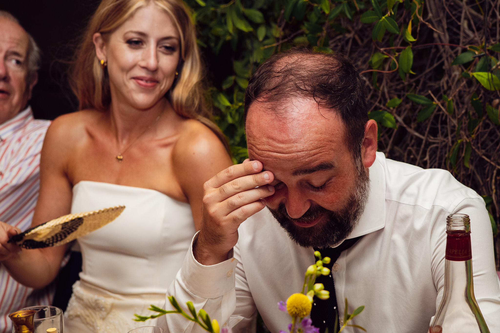 Groom hangs his head as he listens to the best man speech