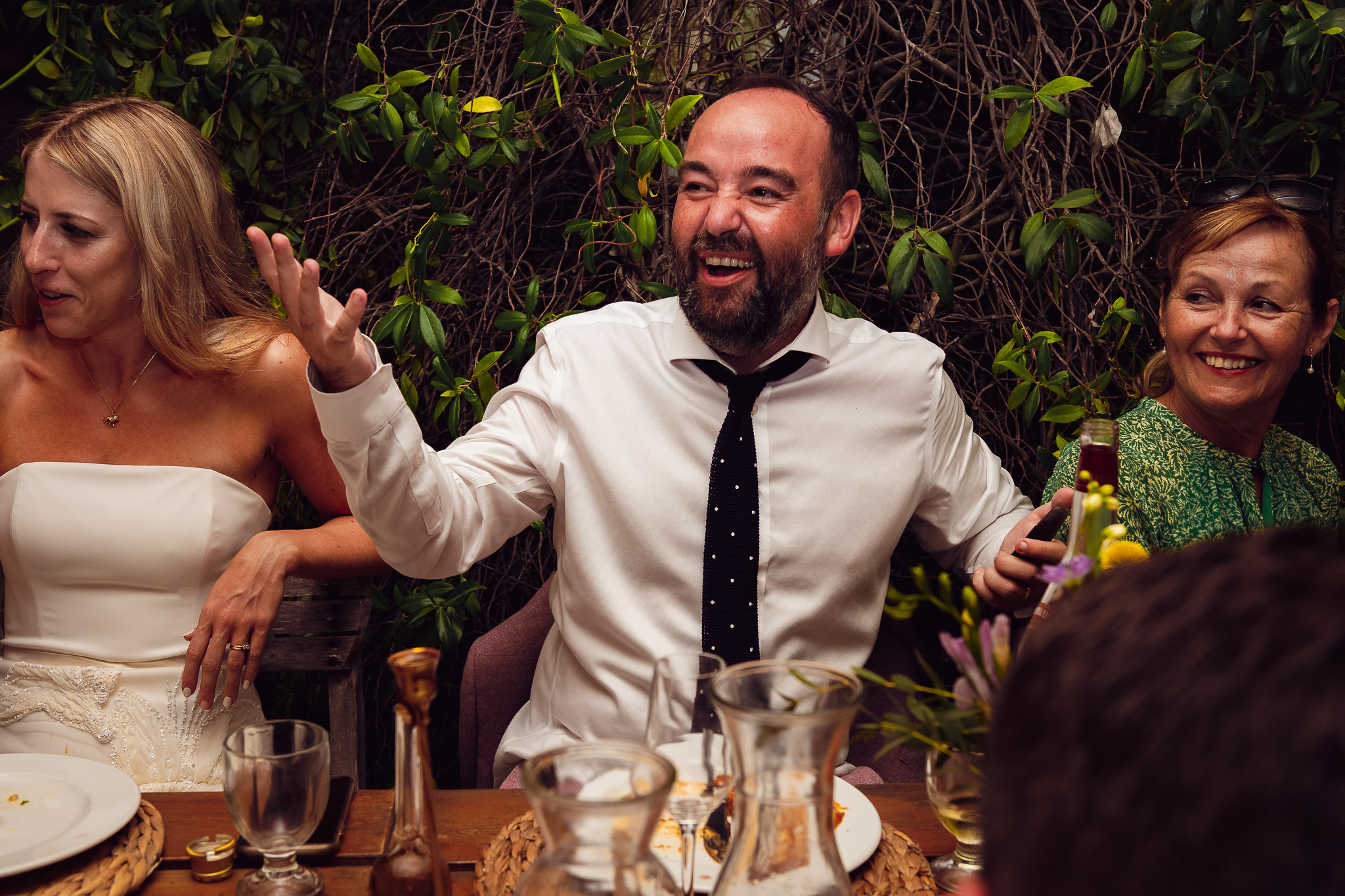 Groom laughs and gestures during the best man speech