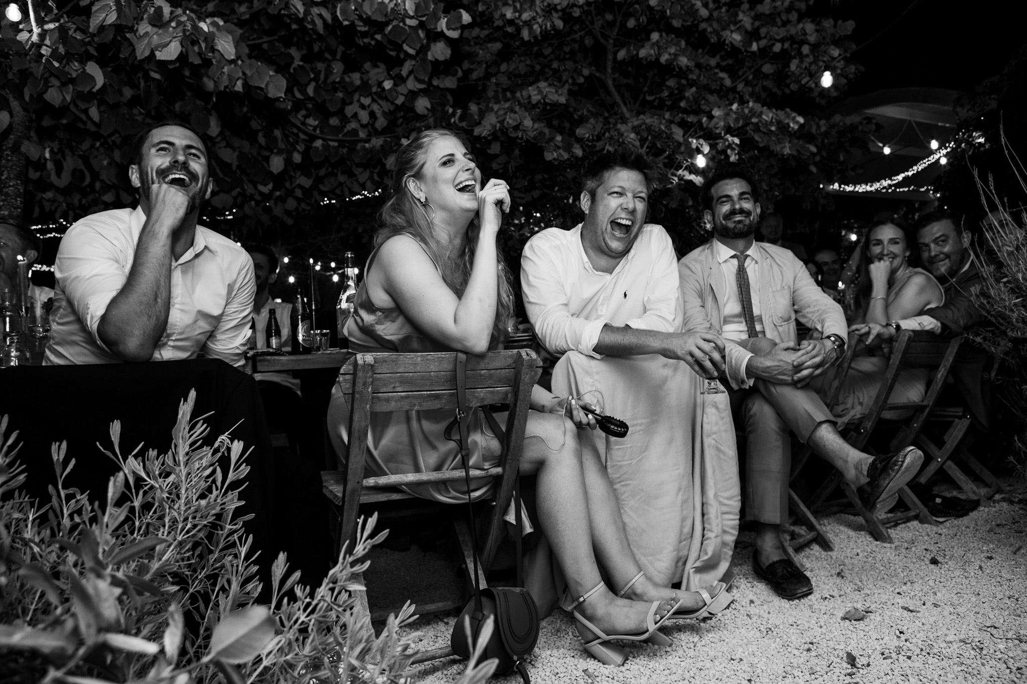 Guests laughing at best man speech whilst sitting at the wedding dinner table at Ambleonas Vineyard, Corfu