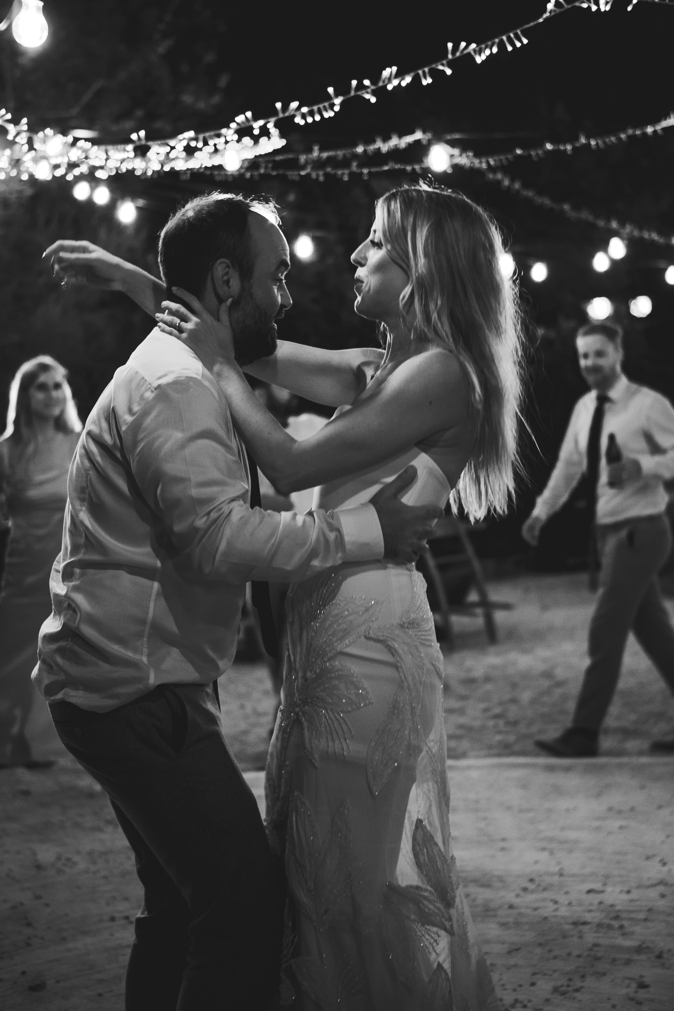 Bride and groom have their first dance under a canopy of fairy lights at their destination wedding