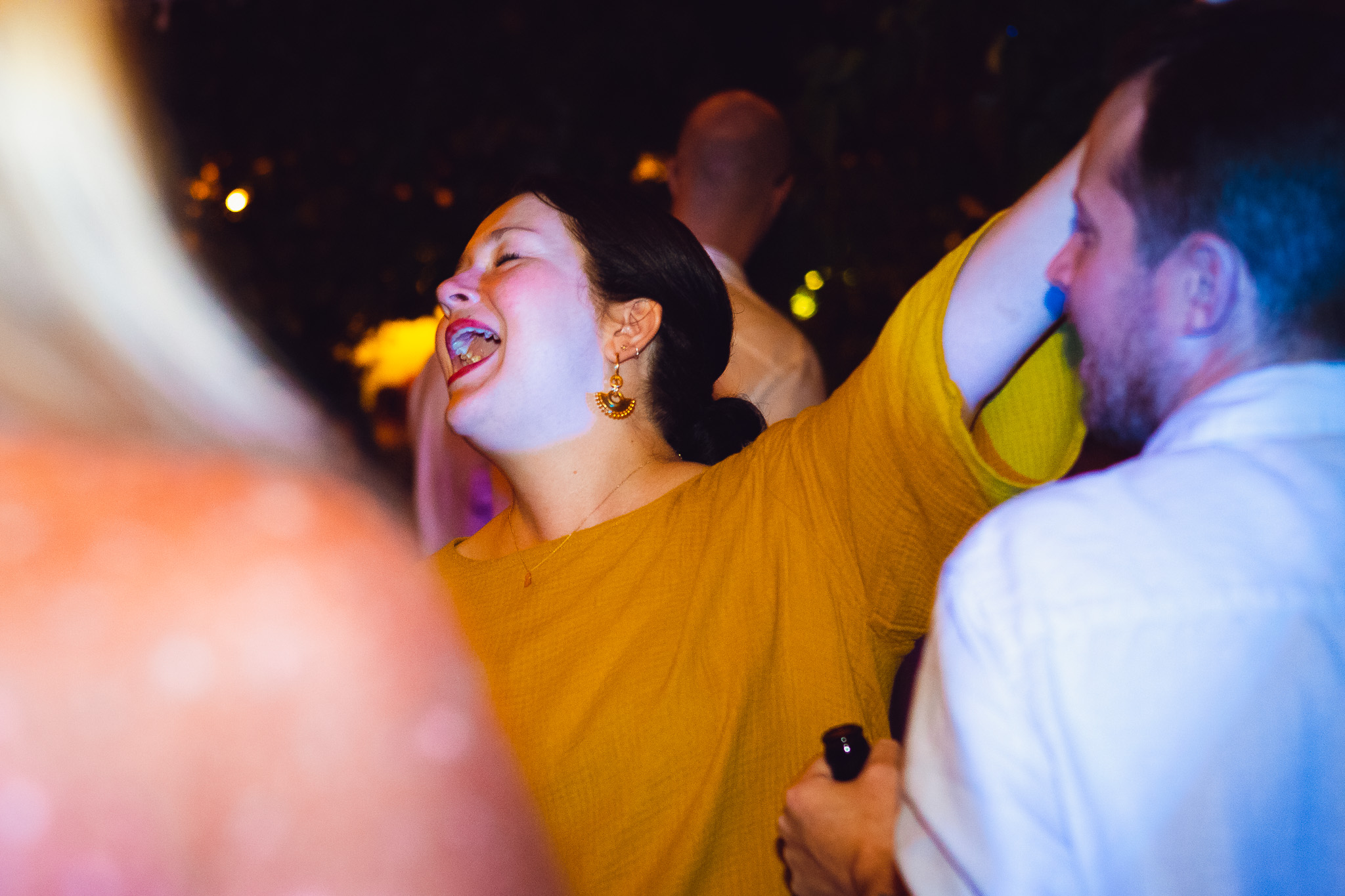 Bridesmaid sings as she enjoys the music as she dances at a wedding reception