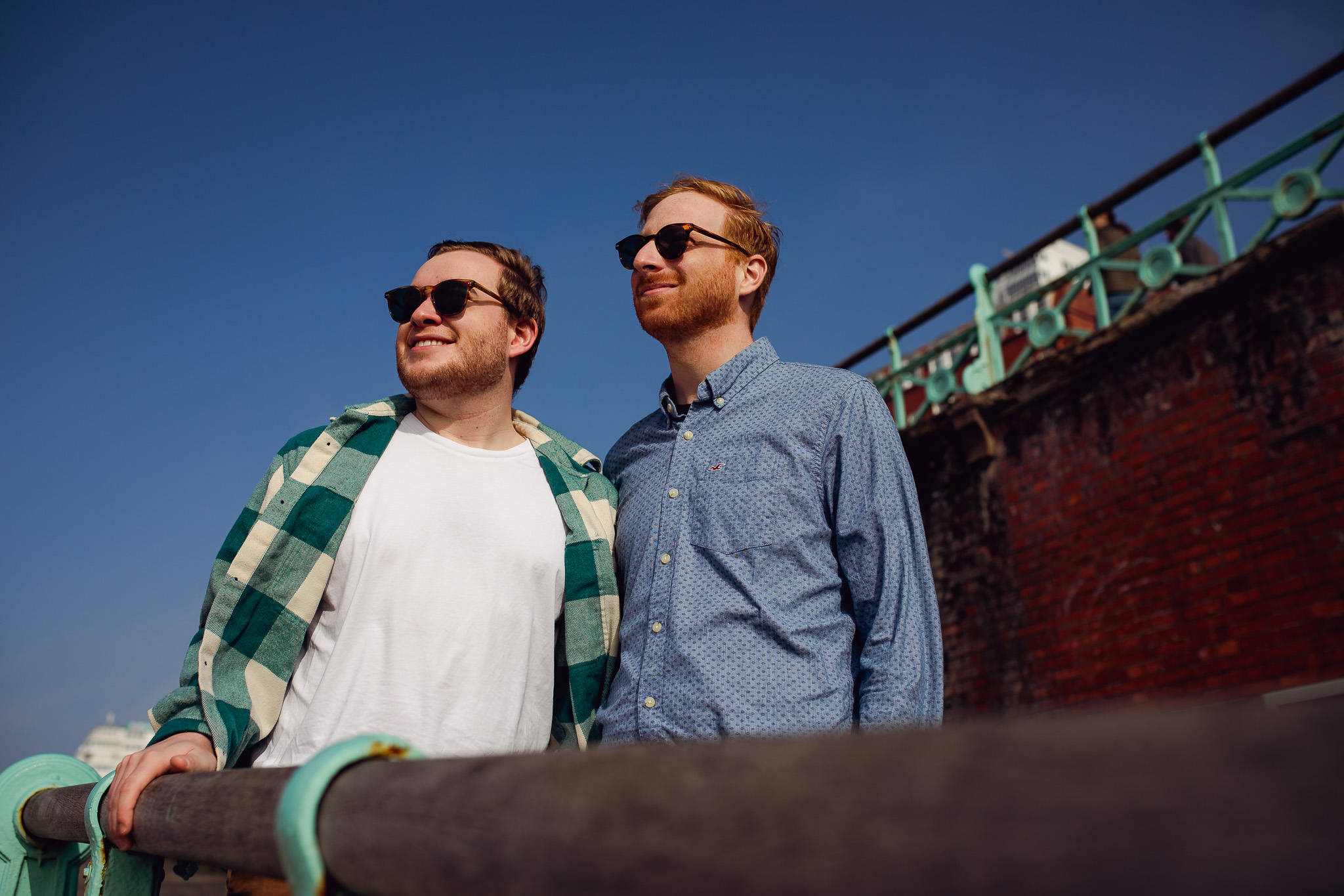 LGBTQ+ couple looking out into the distance on the ramp down to Brighton promenade