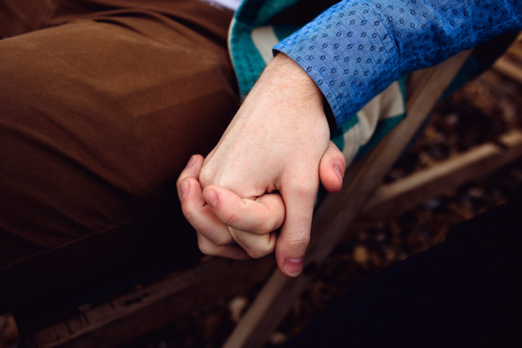 close up of an LGBTQ+ couple holding hands at their engagement session