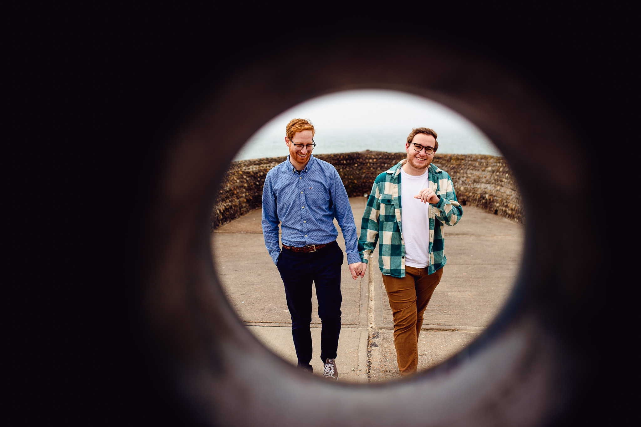 LGBTQ+ couple walking and holding hands at their engagement session near Brighton Beach