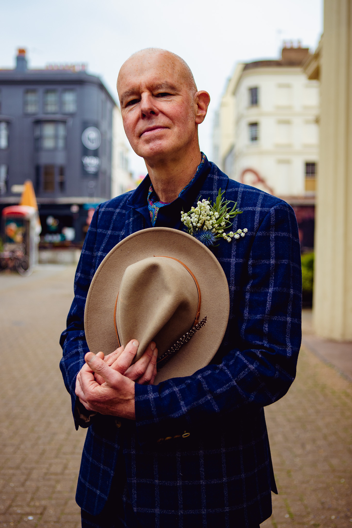 Mike looks ahead and smiles as he holds his fedora as he arrives at Brighton Town Hall for his wedding.