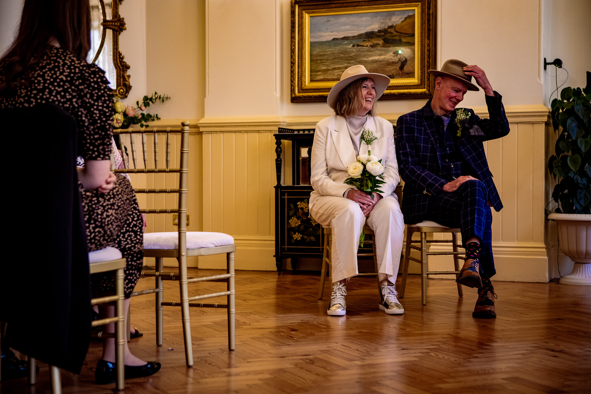 Mary and Mike sit together laughing during their wedding ceremony at Brighton Town Hall.