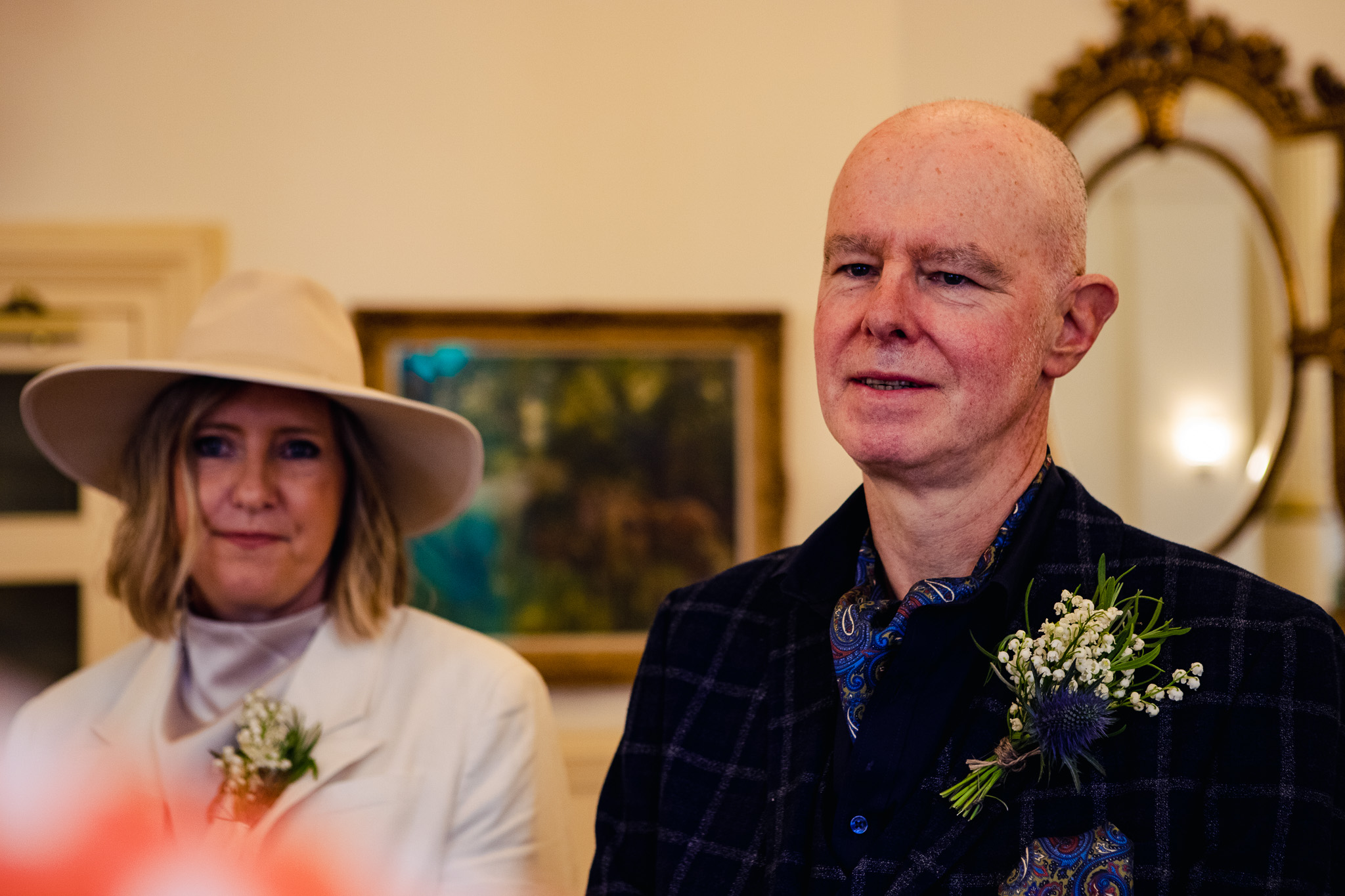 Mary and Mike stand side by side looking during their wedding ceremony at Brighton Town Hall.