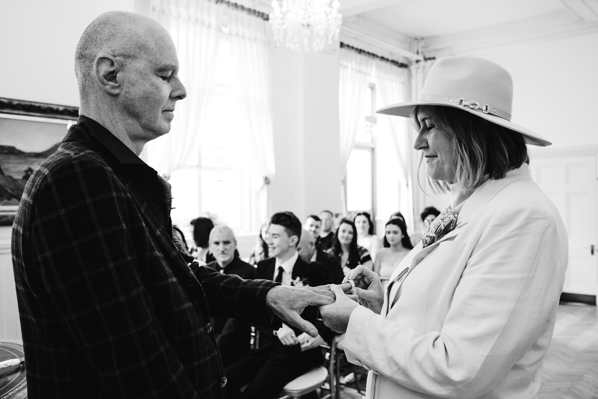 Mary smiles as she puts on Mike's wedding ring at Brighton Town Hall during their wedding ceremony.