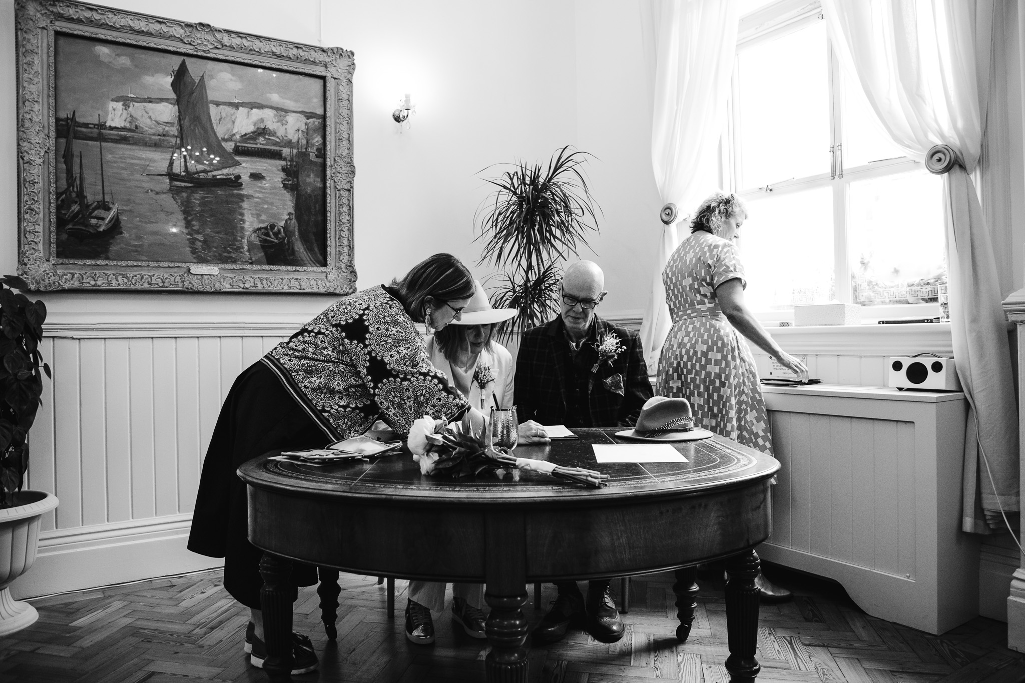 Mary and Mike signing their marriage certificates with their two wedding officiants at Brighton Town Hall.