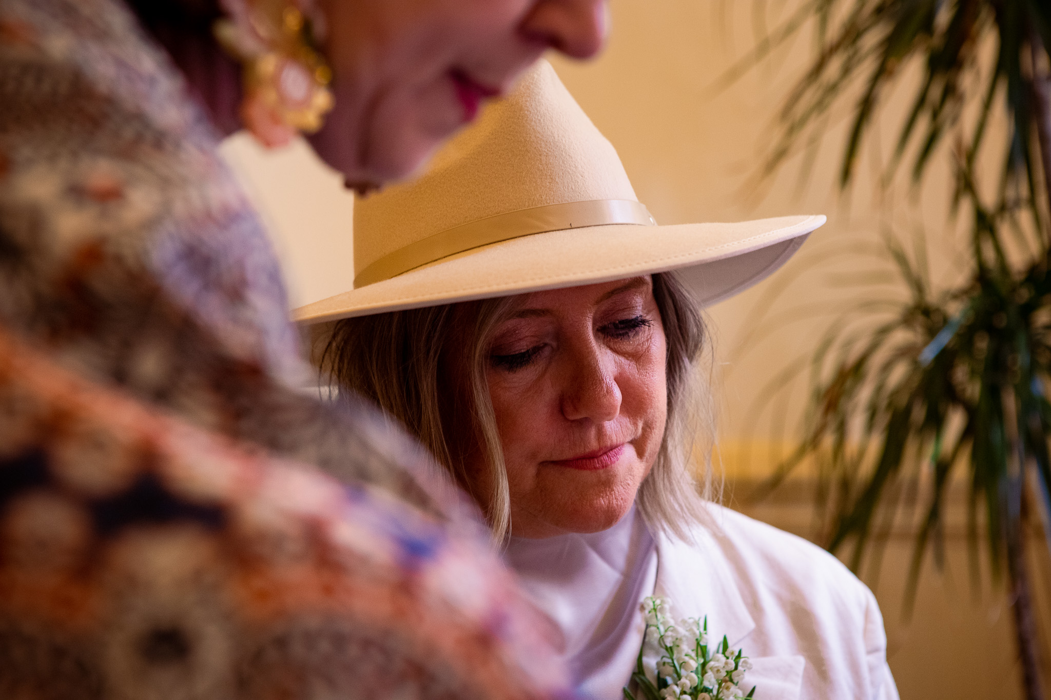 Mary looking down whilst signing her marriage certificate with the officiant in the foreground.