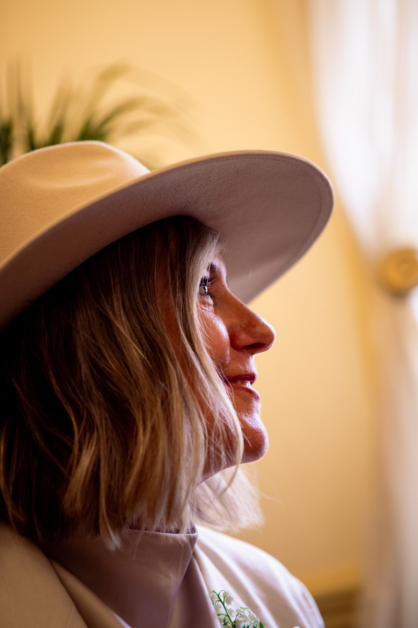 Mary looks up with the sun highlighting her smiling face after her wedding ceremony at Brighton Town Hall.