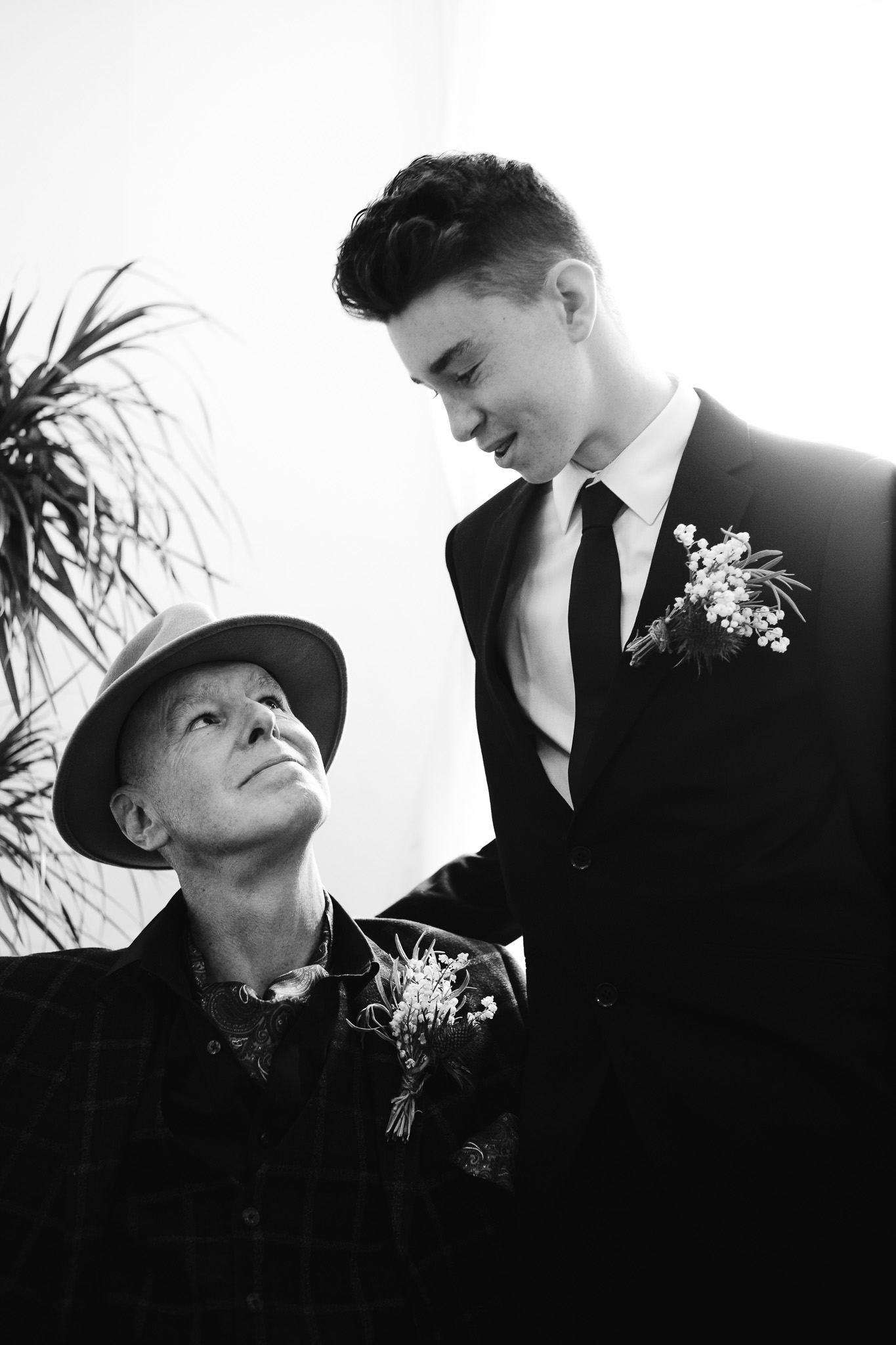 Mike looks up and his son who's standing beside him during the marriage certificate signing at Brighton Town Hall.