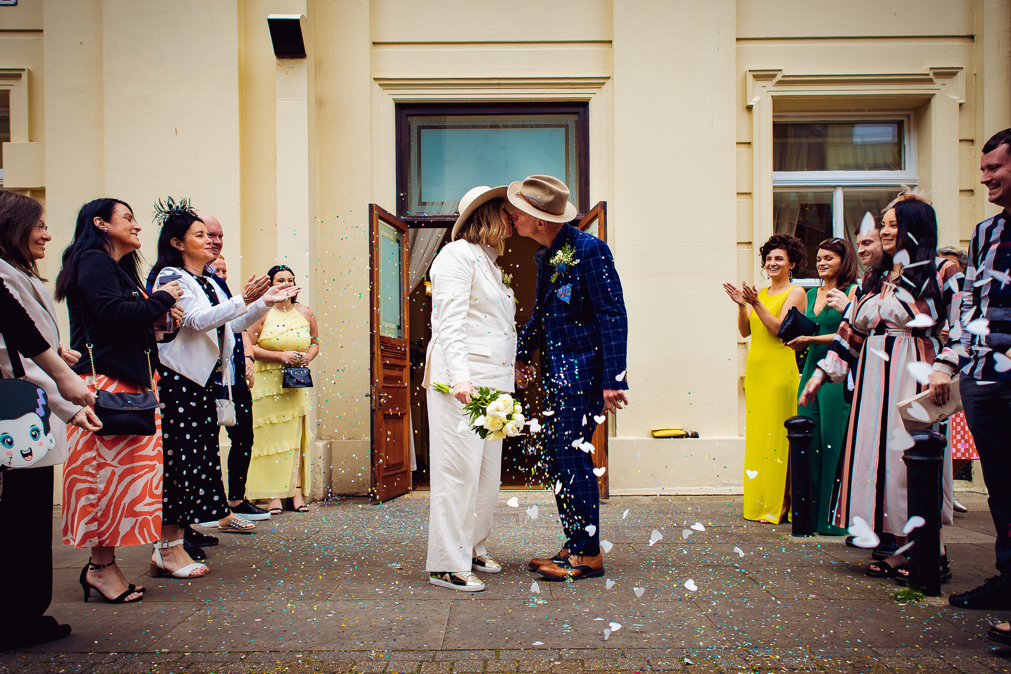 Mary and Mike kiss as confetti is thrown at them after their wedding ceremony at Brighton Town Hall.
