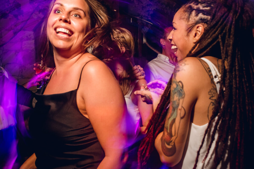 Helen and Shirin dancing at a wedding reception to a DJ playing a set based on Rozewin Photography's wedding playlist