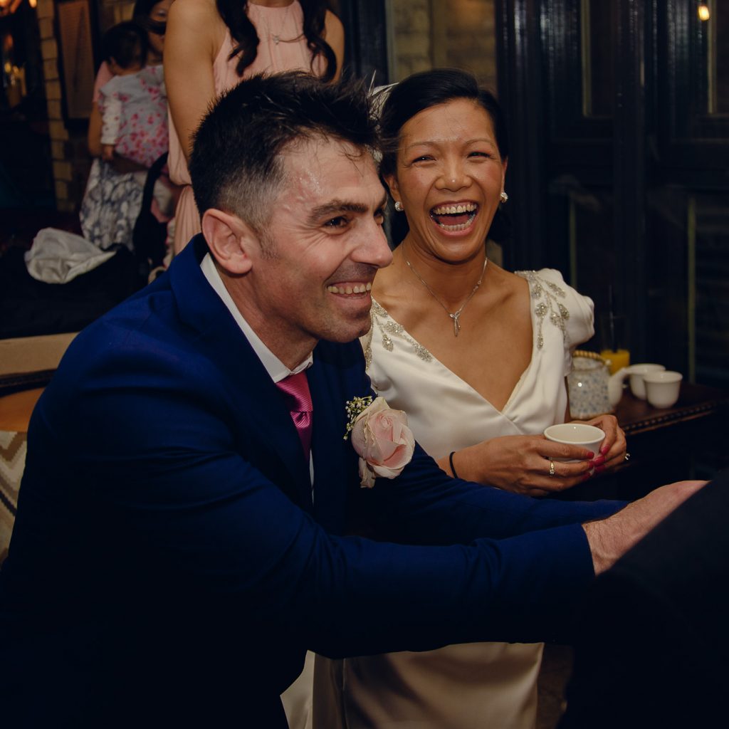 Bride and groom smiling at a wedding tea ceremony at Samuel Pepys in London.